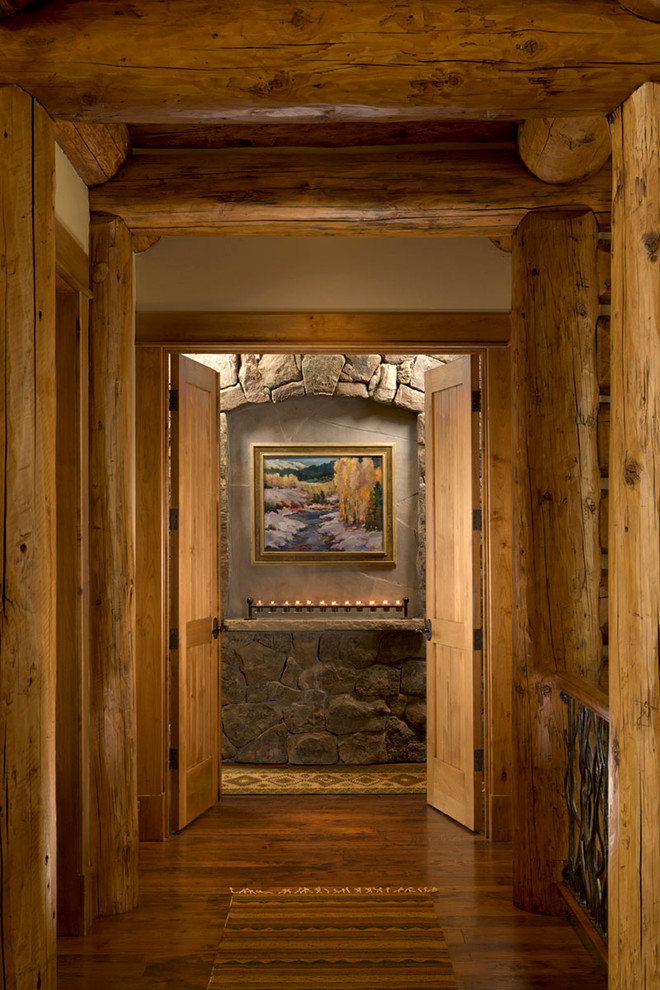 Hallway - large rustic dark wood floor hallway idea in Denver with beige walls