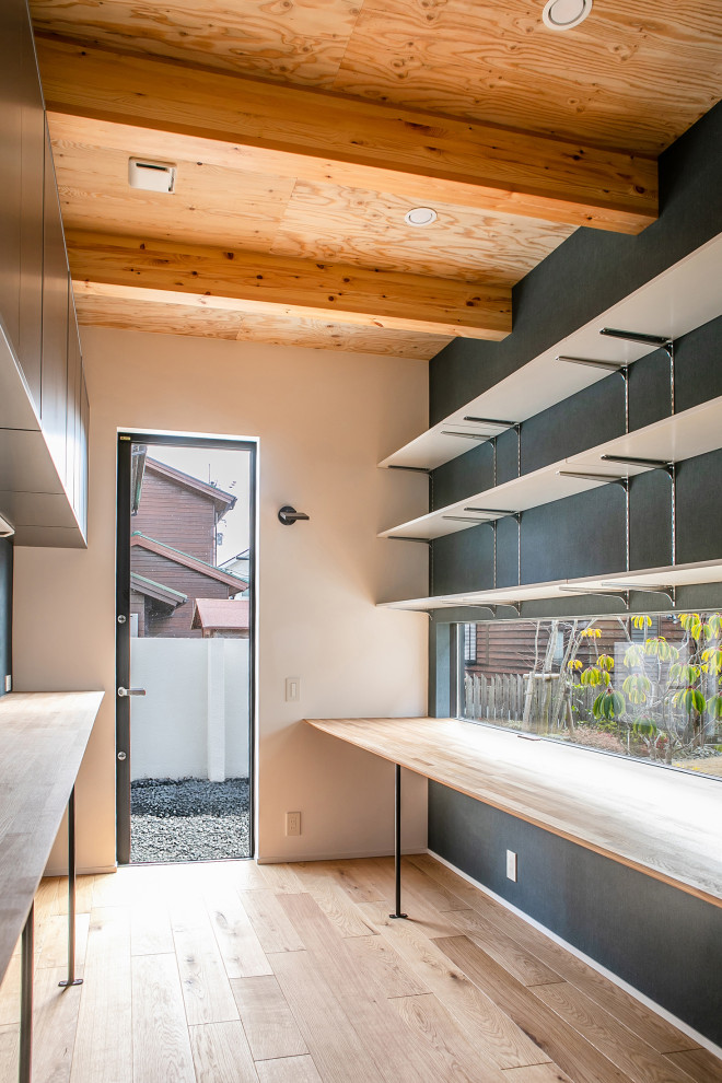 Contemporary home studio in Kyoto with blue walls, light hardwood floors, no fireplace, a built-in desk and wood.