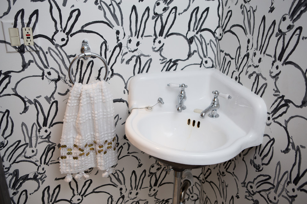Example of a small transitional u-shaped porcelain tile and gray floor powder room design in Chicago with a farmhouse sink, shaker cabinets, gray cabinets, limestone countertops, white backsplash, subway tile backsplash, black appliances, an island, a two-piece toilet, multicolored walls and a pedestal sink