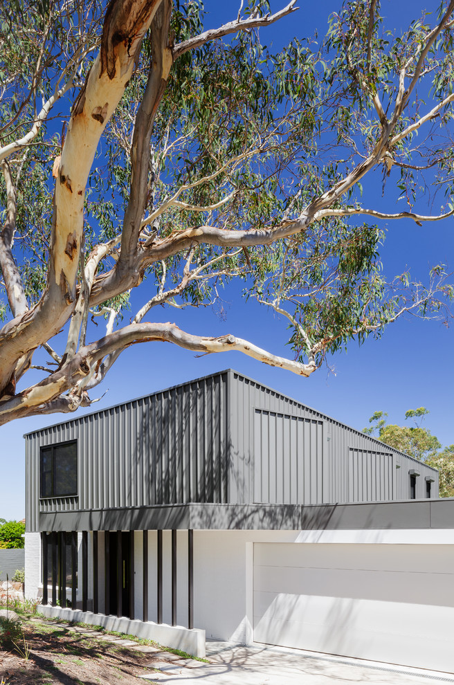Photo of a large contemporary two-storey exterior in Sydney with metal siding.