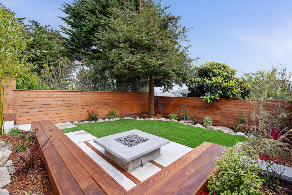 Esempio di un giardino xeriscape classico esposto in pieno sole di medie dimensioni e dietro casa con pavimentazioni in cemento e recinzione in legno