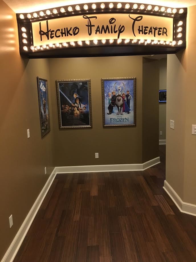 Photo of a large modern open concept home theatre in Cleveland with beige walls, medium hardwood floors and a projector screen.