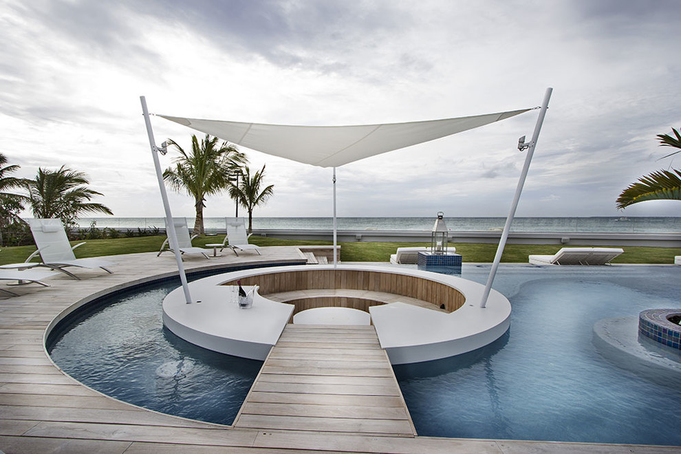 Inspiration for a contemporary backyard custom-shaped pool in New York with decking.