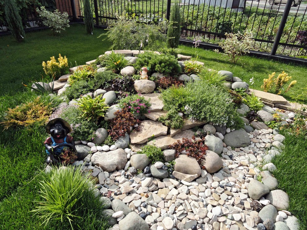 Traditional full sun formal garden in Other with gravel and with rock feature.