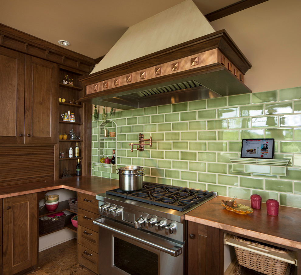 This is an example of a traditional l-shaped separate kitchen in Portland with an undermount sink, recessed-panel cabinets, medium wood cabinets, copper benchtops, green splashback, subway tile splashback and panelled appliances.