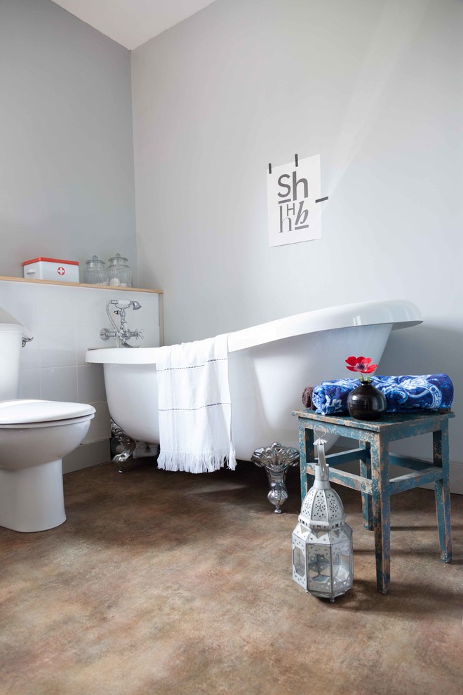 Photo of a mid-sized contemporary master bathroom in Other with a claw-foot tub, a one-piece toilet and grey walls.