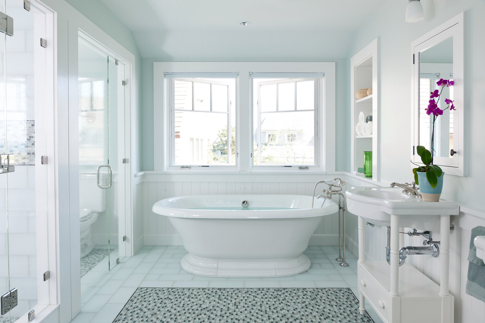 This is an example of a beach style bathroom in Boston with a console sink, white cabinets, a freestanding tub, blue tile, flat-panel cabinets and blue floor.