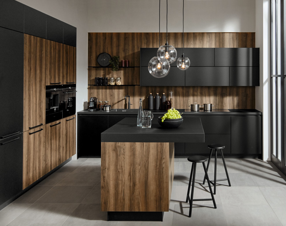 Mid-sized contemporary galley eat-in kitchen in Other with a single-bowl sink, flat-panel cabinets, black cabinets, laminate benchtops, black appliances, ceramic floors, with island, grey floor and black benchtop.