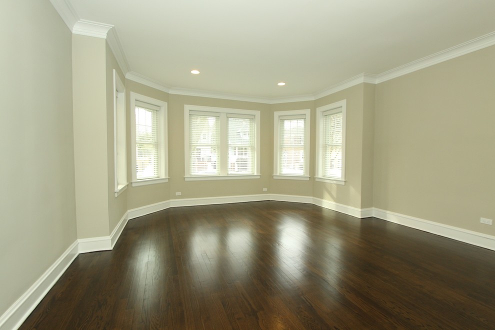 Photo of a mid-sized traditional formal enclosed living room in Chicago with beige walls, dark hardwood floors, a wood stove, a brick fireplace surround, no tv and brown floor.