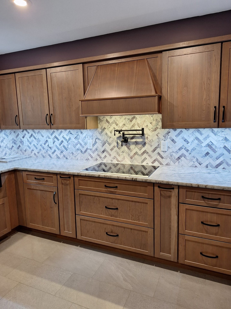 Example of a large transitional u-shaped porcelain tile and gray floor eat-in kitchen design in Boston with a farmhouse sink, shaker cabinets, medium tone wood cabinets, granite countertops, gray backsplash, marble backsplash, stainless steel appliances, a peninsula and gray countertops
