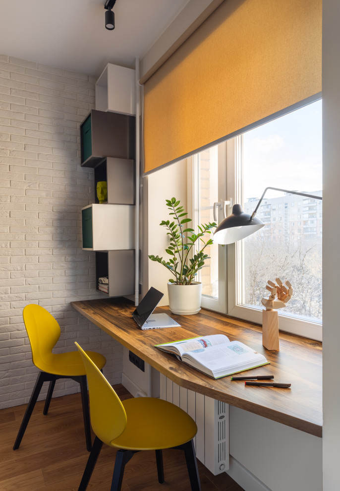 This is an example of a contemporary home office in Moscow with a feature wall.