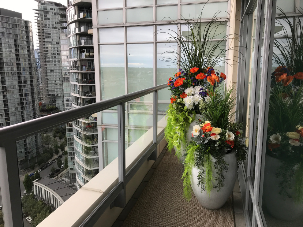 Inspiration for a small traditional balcony in Vancouver with a container garden and glass railing.