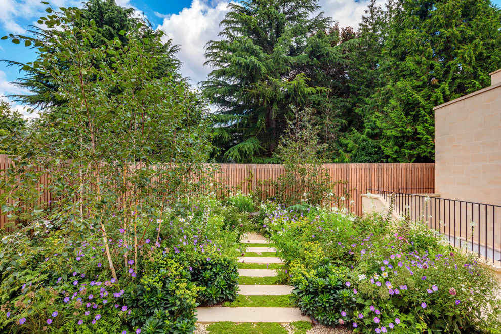 Aménagement d'un jardin arrière contemporain de taille moyenne et l'été avec un chemin, une exposition partiellement ombragée, des pavés en pierre naturelle et une clôture en bois.