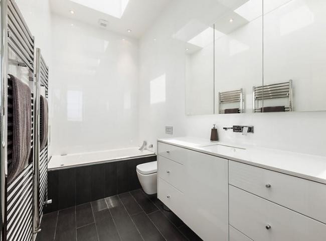 Photo of a large modern bathroom in Melbourne with an undermount sink, flat-panel cabinets, white cabinets, engineered quartz benchtops, a drop-in tub, a corner shower, a one-piece toilet, brown tile, porcelain tile, white walls and porcelain floors.