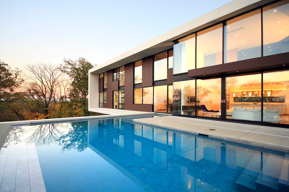 Photo of a contemporary backyard rectangular infinity pool in Los Angeles with a pool house.