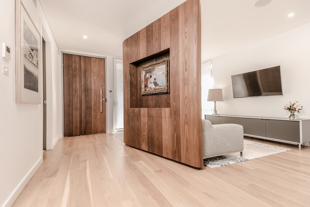 Design ideas for a contemporary entryway in Sydney with white walls, light hardwood floors and a light wood front door.