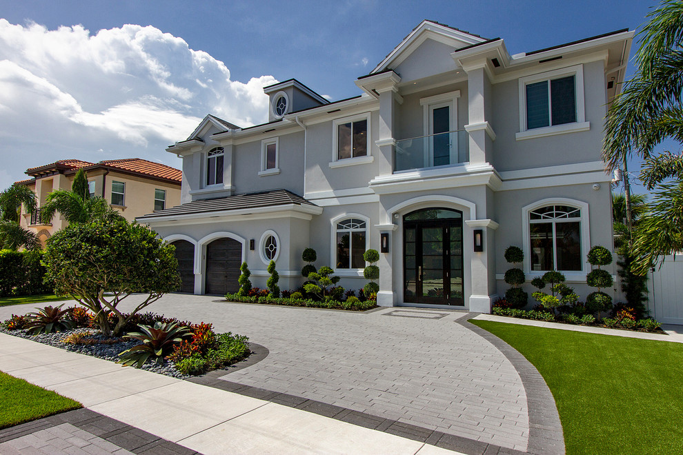 Inspiration for a large transitional two-story stucco gray home design remodel in Miami