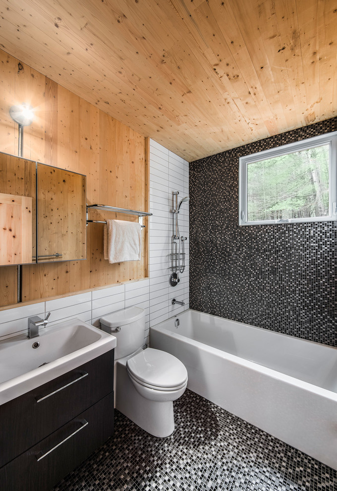 Photo of a contemporary master bathroom in Ottawa with a trough sink, flat-panel cabinets, dark wood cabinets, an alcove tub, a shower/bathtub combo, a two-piece toilet, gray tile, mosaic tile, multi-coloured walls and mosaic tile floors.