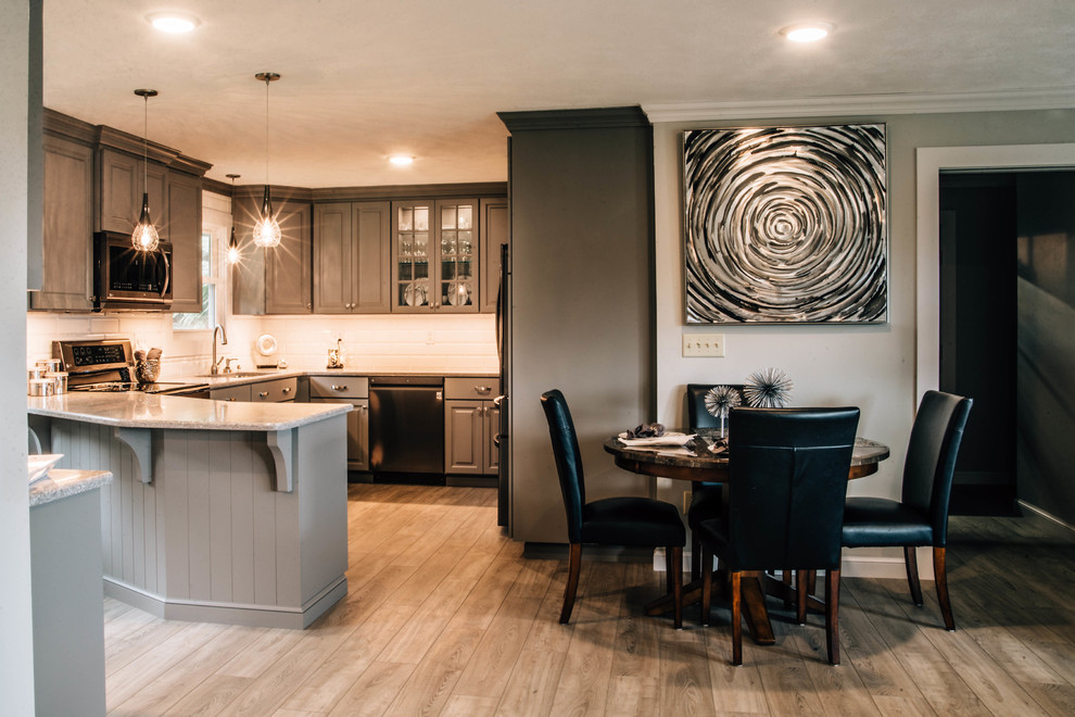 Inspiration for a mid-sized transitional u-shaped medium tone wood floor and brown floor eat-in kitchen remodel with a double-bowl sink, raised-panel cabinets, gray cabinets, granite countertops, white backsplash, ceramic backsplash, stainless steel appliances, a peninsula and gray countertops