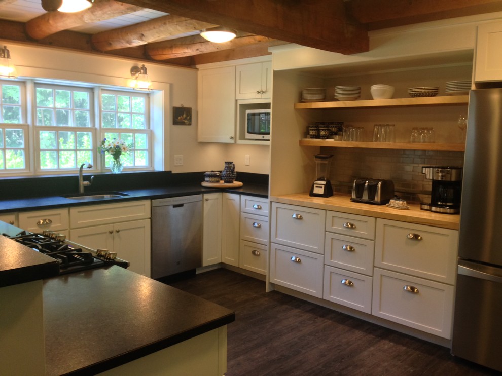 Inspiration for a mid-sized eclectic u-shaped eat-in kitchen in Burlington with shaker cabinets, white cabinets, granite benchtops, no island, an undermount sink, black splashback, stone slab splashback, stainless steel appliances and vinyl floors.
