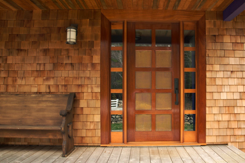 This is an example of an arts and crafts front door in Boston with a single front door and a medium wood front door.