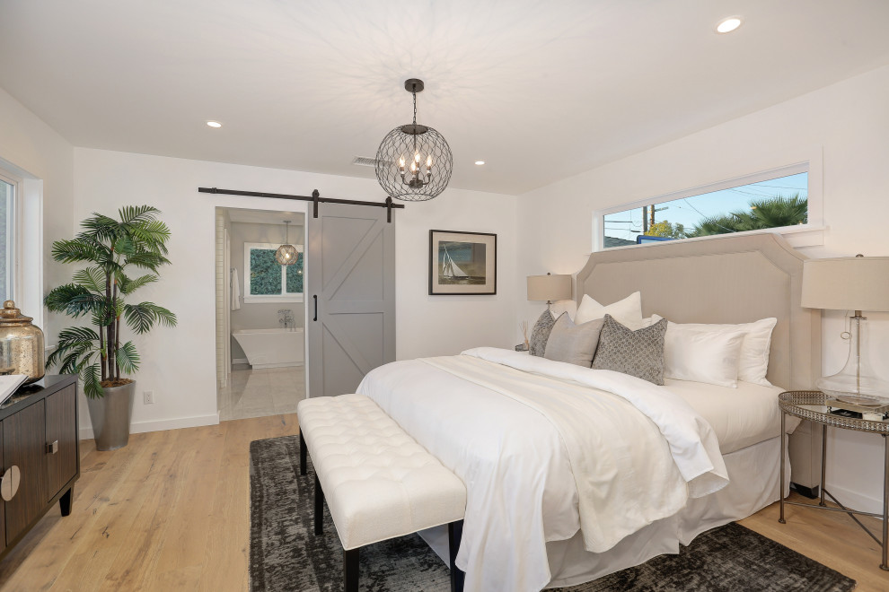 Inspiration for a mid-sized transitional master bedroom in Los Angeles with white walls, light hardwood floors and beige floor.