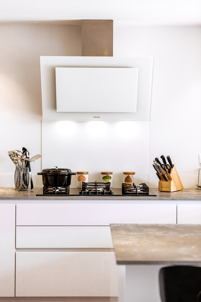 Idée de décoration pour une grande cuisine ouverte minimaliste en U avec un évier 1 bac, une crédence blanche, un électroménager blanc, un sol marron et un plan de travail gris.