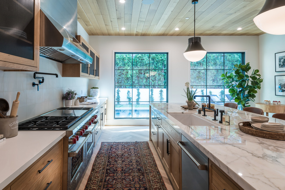 Aménagement d'une très grande cuisine américaine blanche et bois classique avec un électroménager en acier inoxydable, îlot, un plan de travail blanc et un plafond en bois.
