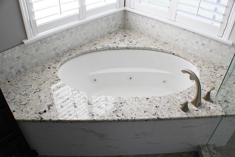 Inspiration for a mid-sized transitional master bathroom in Cincinnati with white tile, grey walls, an undermount tub, a corner shower, marble, dark hardwood floors, brown floor and a hinged shower door.