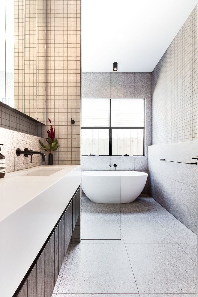 Inspiration for a mid-sized contemporary master bathroom in Melbourne with a freestanding tub, gray tile, porcelain tile, engineered quartz benchtops, white benchtops, flat-panel cabinets, dark wood cabinets, a curbless shower, grey walls, an undermount sink, grey floor and an open shower.