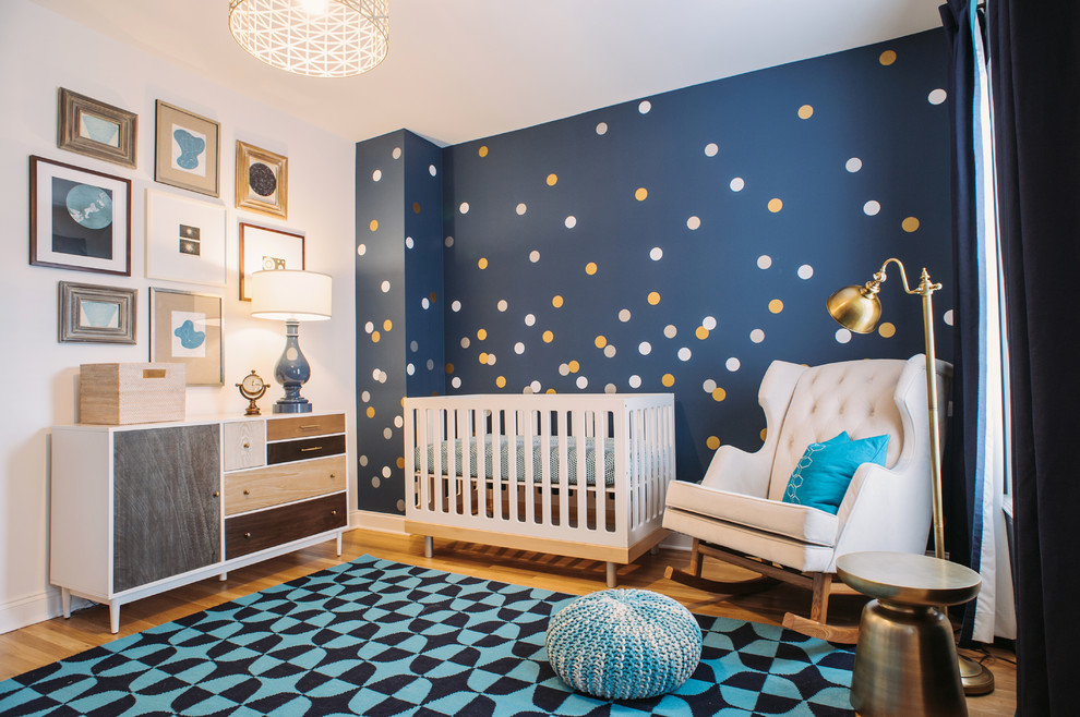 Photo of a mid-sized transitional nursery for boys in Chicago with blue walls and light hardwood floors.