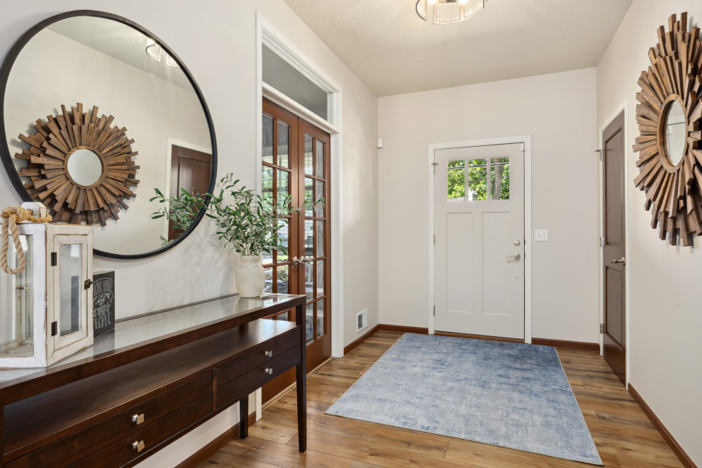 Foyer - mid-sized transitional vinyl floor and brown floor foyer idea in Minneapolis with beige walls and a white front door
