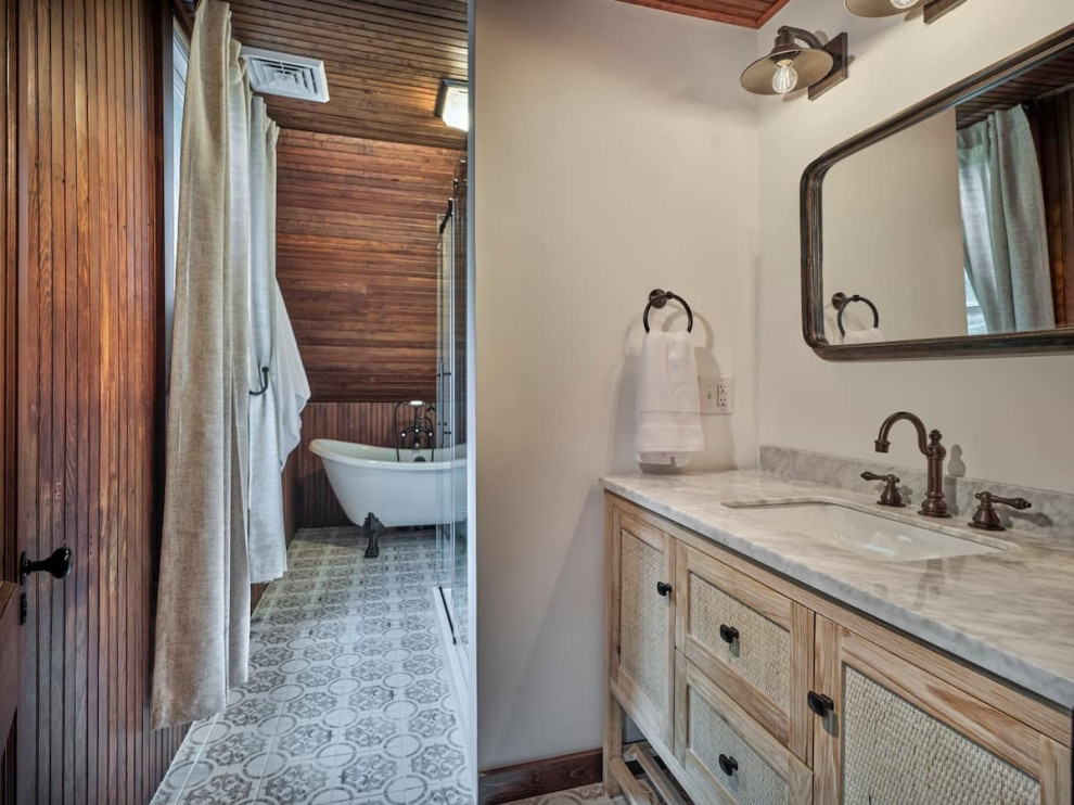 Foto på ett rustikt vit badrum, med skåp i ljust trä, ett fristående badkar och marmorbänkskiva