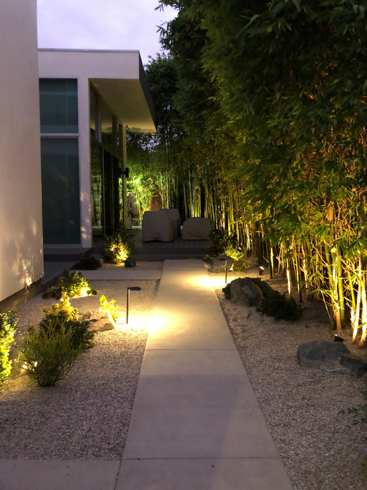 This is an example of a mid-sized modern front yard full sun xeriscape in Los Angeles with with rock feature and gravel.
