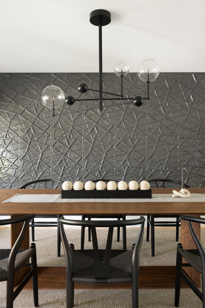 Imagen de comedor contemporáneo de tamaño medio cerrado con paredes negras, suelo de madera clara, chimenea de doble cara, marco de chimenea de yeso y panelado