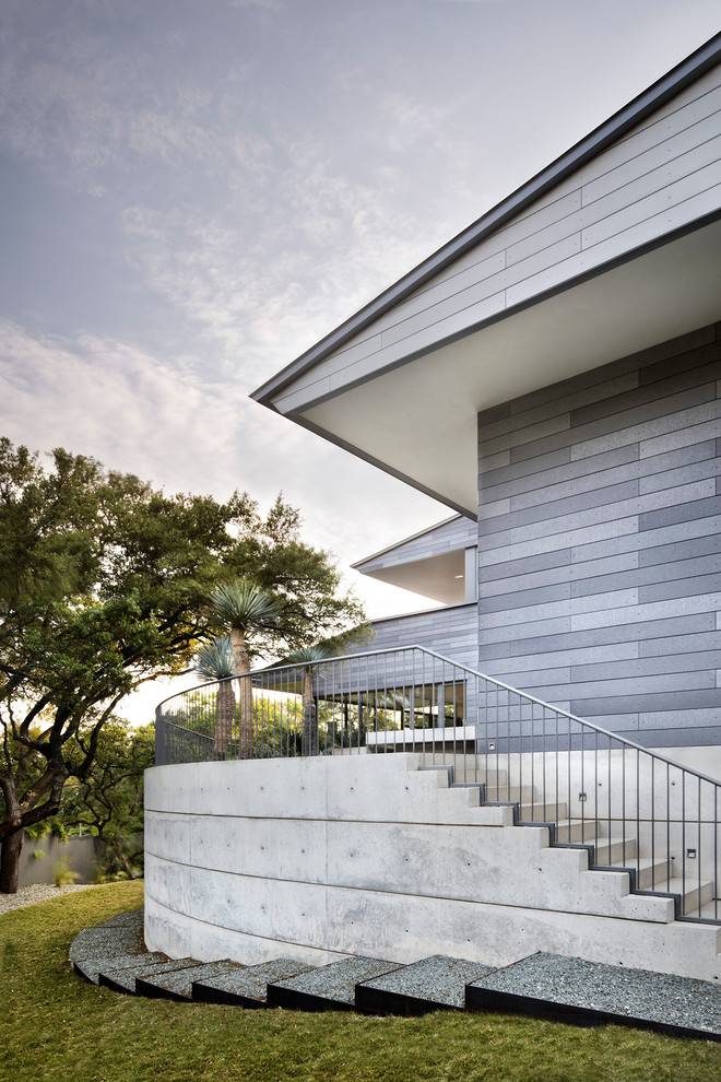 Inspiration for a large midcentury grey house exterior in Austin with concrete fiberboard siding.