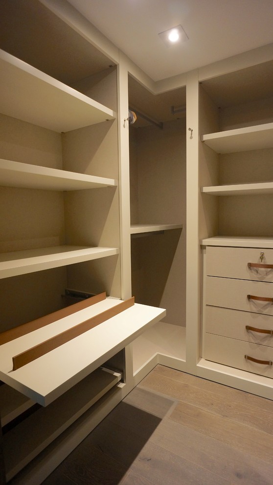 Mid-sized contemporary men's dressing room in Miami with flat-panel cabinets, light wood cabinets and light hardwood floors.