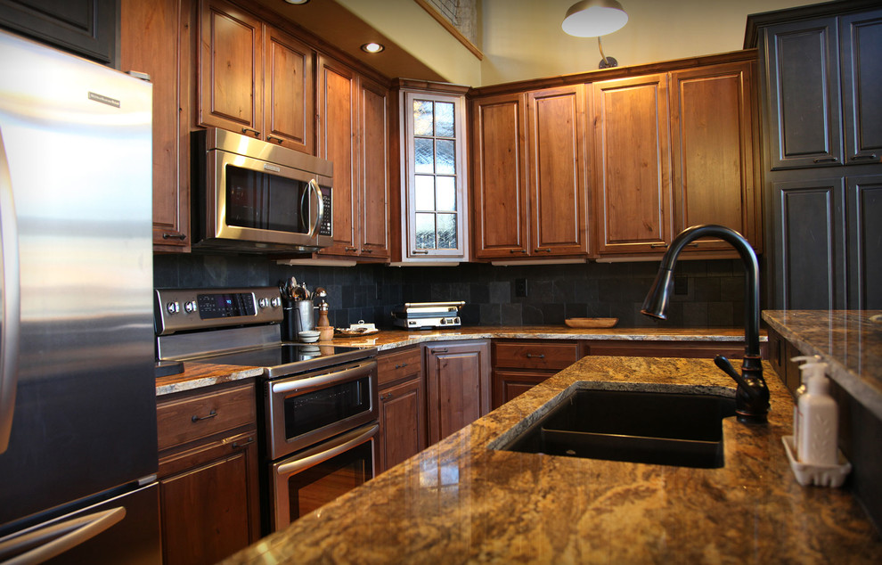 Example of a mid-sized mountain style l-shaped kitchen design with a double-bowl sink, raised-panel cabinets, medium tone wood cabinets, granite countertops, stainless steel appliances and an island