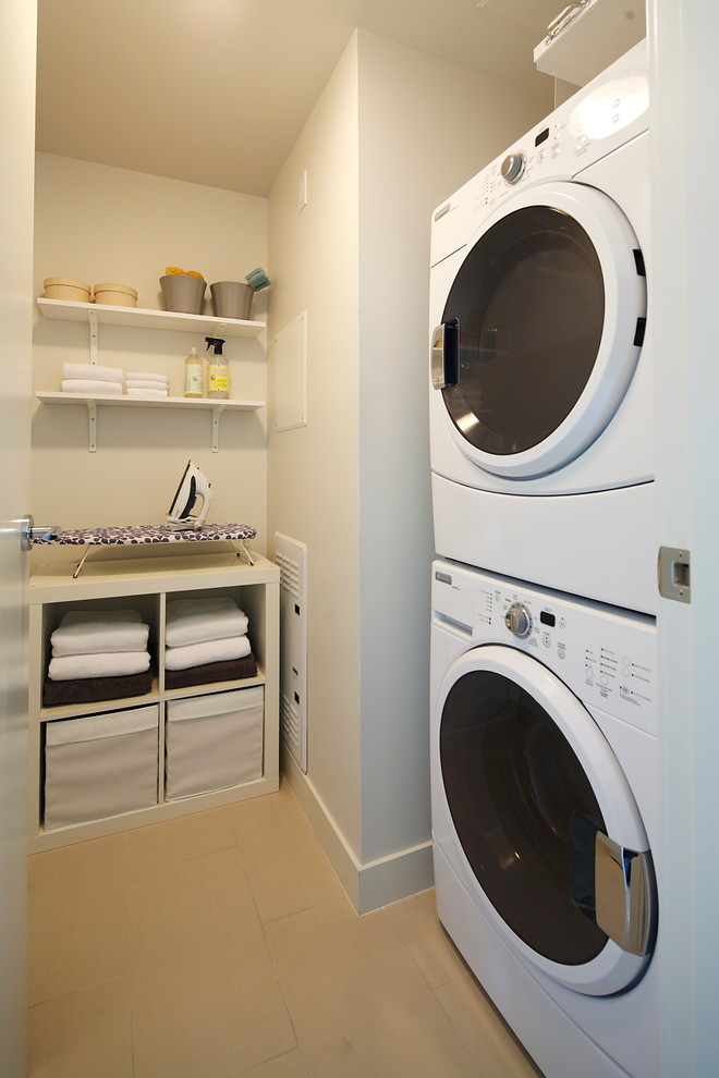 Photo of a contemporary laundry room in Calgary with a stacked washer and dryer.