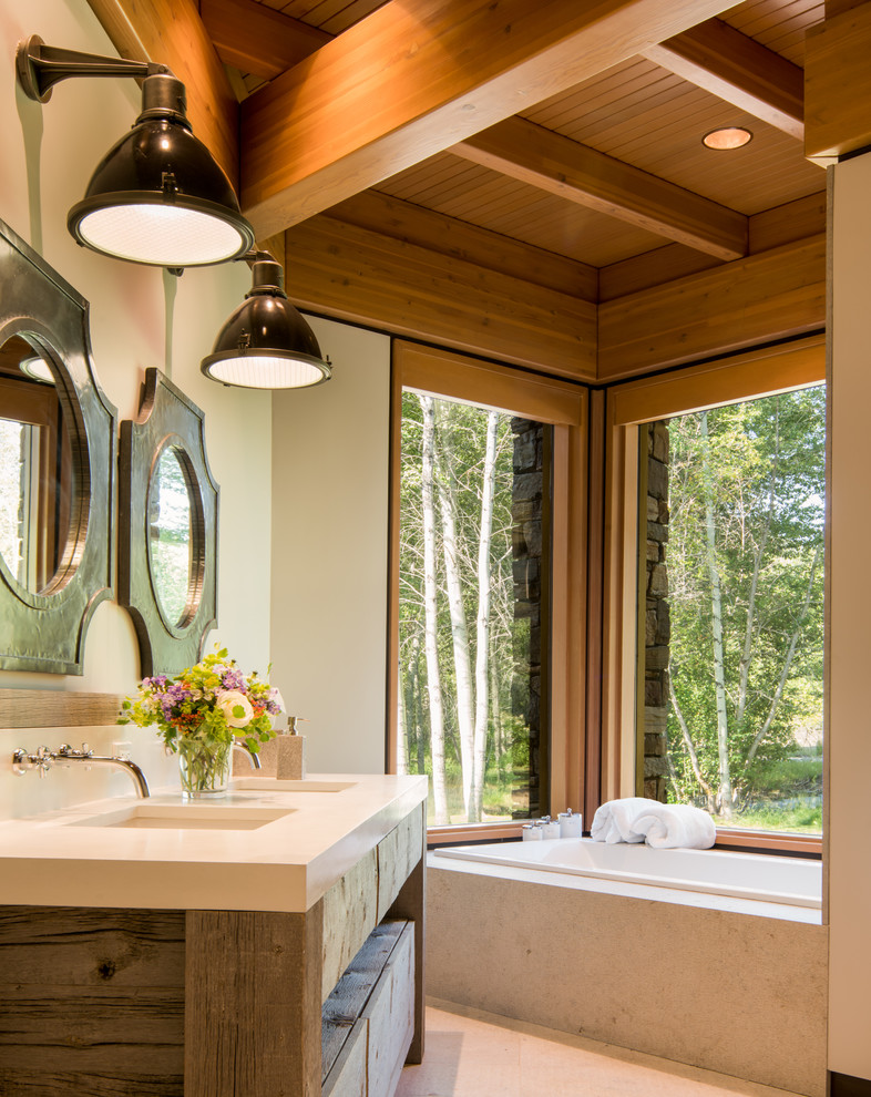 Photo of a mid-sized country master bathroom in Other with medium wood cabinets, a drop-in tub, beige walls, an undermount sink, engineered quartz benchtops, beige floor and flat-panel cabinets.