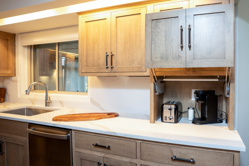 Eat-in kitchen - large transitional l-shaped medium tone wood floor and brown floor eat-in kitchen idea with a single-bowl sink, shaker cabinets, medium tone wood cabinets, quartz countertops, white backsplash, quartz backsplash, stainless steel appliances, an island and white countertops