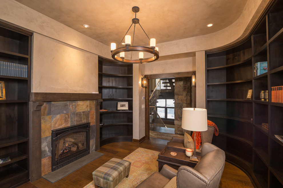 Mid-sized country home office in Salt Lake City with a library, beige walls, dark hardwood floors, a standard fireplace and a stone fireplace surround.