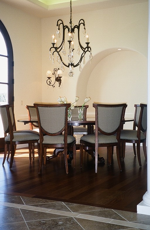This is an example of a traditional kitchen/dining combo in Austin with yellow walls and dark hardwood floors.