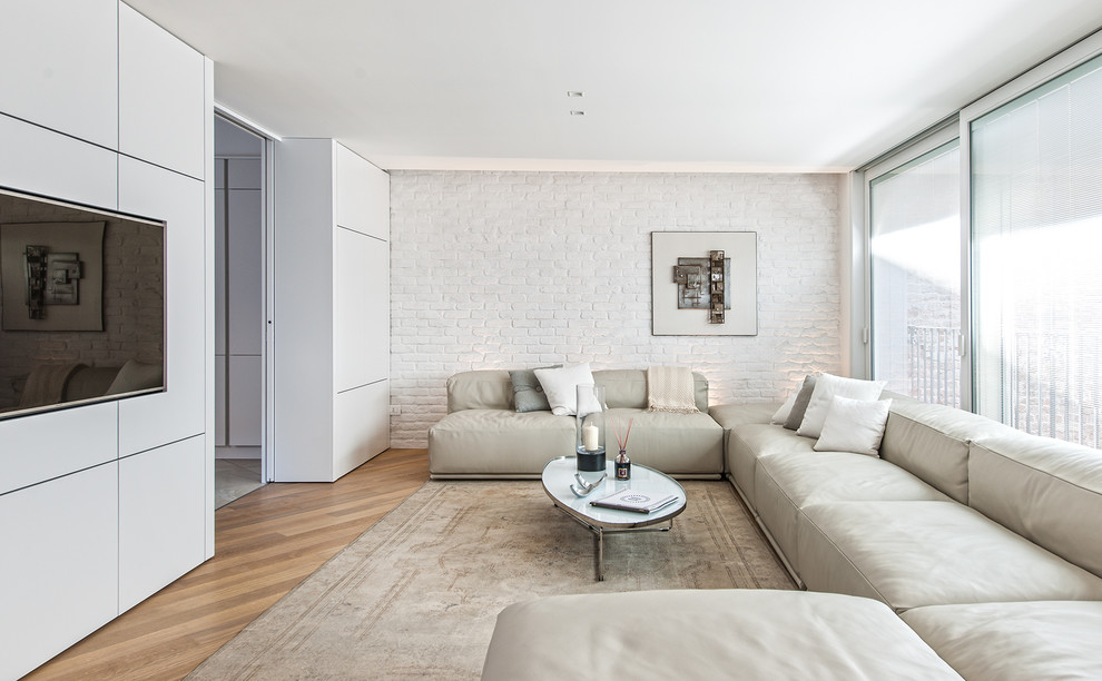 Photo of a contemporary enclosed family room in Milan with white walls and light hardwood floors.