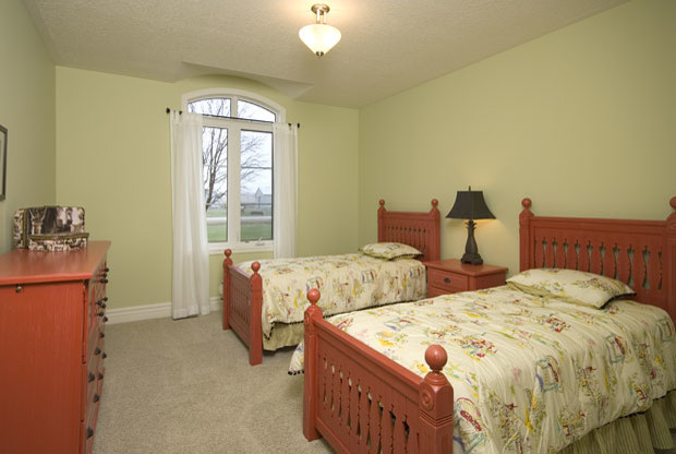 Example of a large classic guest carpeted bedroom design in Toronto with green walls and no fireplace