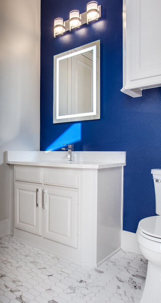 Inspiration for a large transitional powder room in Dallas with raised-panel cabinets, white cabinets, a one-piece toilet, blue walls, porcelain floors, an undermount sink, engineered quartz benchtops, white floor and white benchtops.