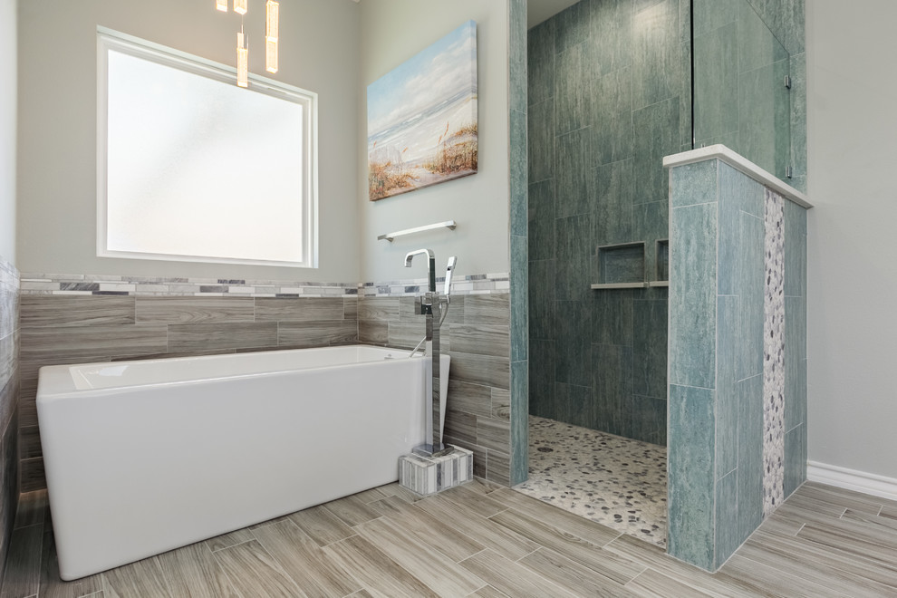 Inspiration for a mid-sized beach style master bathroom in Austin with shaker cabinets, grey cabinets, a freestanding tub, an open shower, blue tile, porcelain tile, grey walls, porcelain floors, an undermount sink and engineered quartz benchtops.