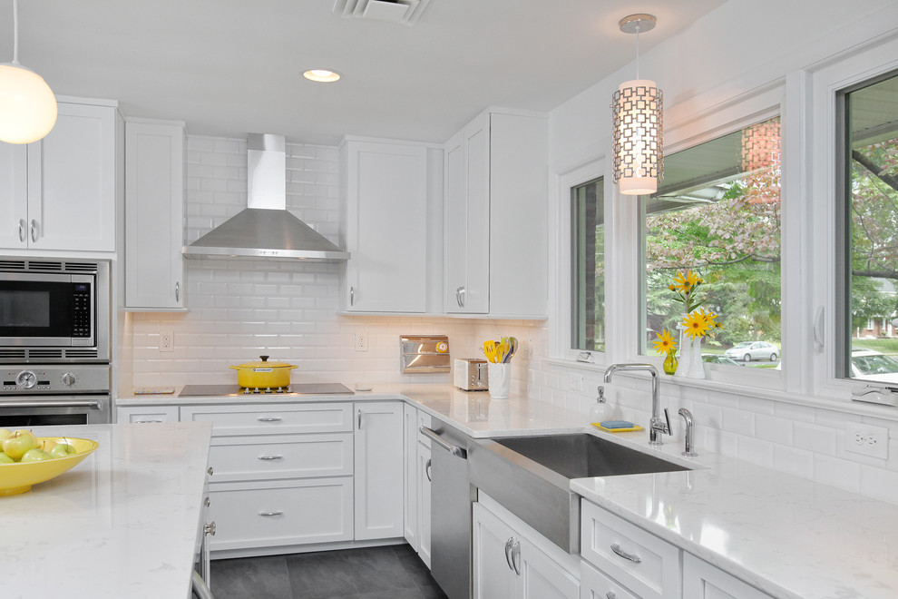 Design ideas for a mid-sized transitional l-shaped open plan kitchen in Philadelphia with a farmhouse sink, shaker cabinets, white cabinets, marble benchtops, white splashback, subway tile splashback, stainless steel appliances, slate floors and with island.