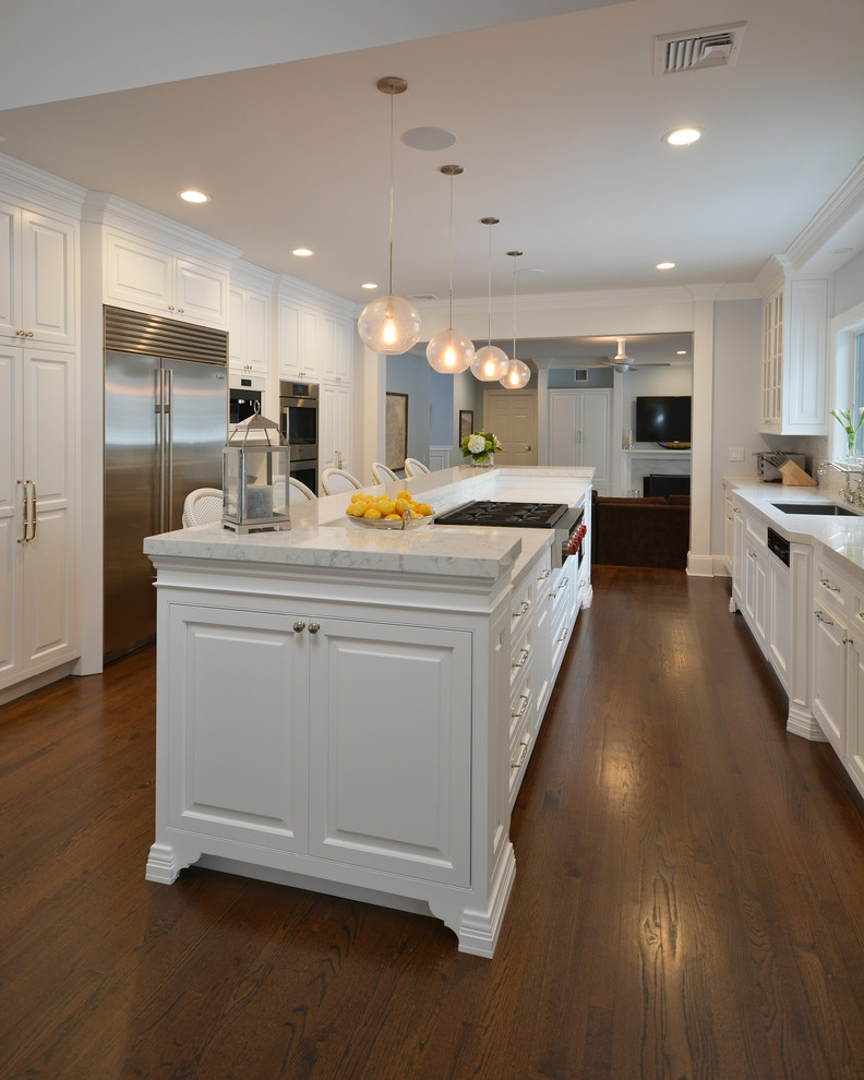 Eat-in kitchen - transitional galley medium tone wood floor eat-in kitchen idea in New York with an undermount sink, recessed-panel cabinets, white cabinets, white backsplash, white appliances and an island
