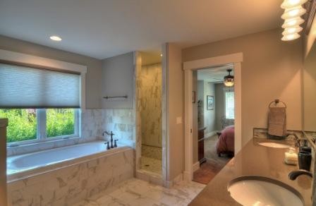 Design ideas for an expansive traditional master bathroom in Seattle with an undermount sink, flat-panel cabinets, dark wood cabinets, concrete benchtops, a drop-in tub, an alcove shower, a one-piece toilet, white tile, stone tile, beige walls and marble floors.